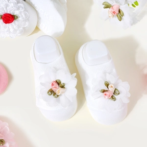 Detail of baby cotton socks with exquisite white lace flowers and delicate ribbon accents