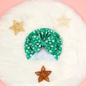 Détail d'un turban bébé vert avec trèfles et un grand nœud pour la Saint-Patrick