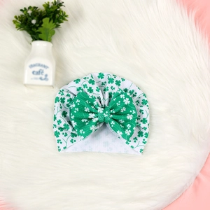 Détail du bonnet bébé Saint-Patrick avec trèfles verts et grand nœud décoratif