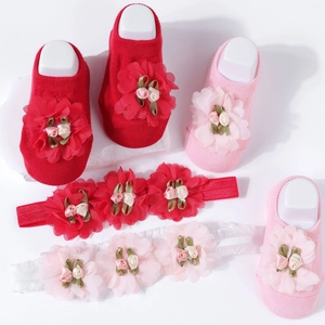 Detail of baby flower headbands and cotton socks set in pink and red with floral accents