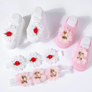 Detailed view of floral baby headbands and matching knit socks in pink and white colors