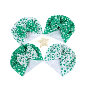 Détail de quatre bonnets bébé Saint-Patrick avec motifs trèfle vert et nœuds papillon