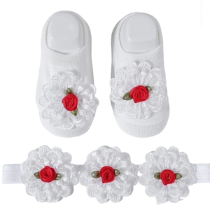 Close-up of baby socks and headband set with white lace flowers and red roses