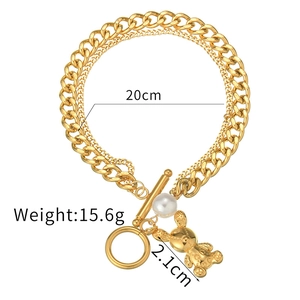 Detail of gold double-layer chain bracelet with pearl, animal pendant and OT toggle clasp