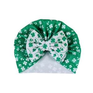 Détail du turban bébé vert pour la Saint-Patrick avec motif trèfle et gros nœud décoratif
