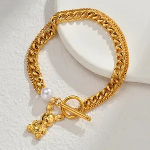 Gold double-layered bracelet with pearl accents, bear pendant, and vintage OT toggle clasp