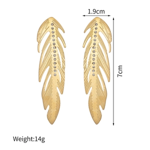 Détail des boucles d'oreilles plume dorées avec strass montrant 7 cm de long et 1,9 cm de large