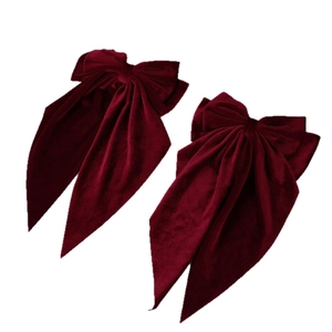 Pair of large burgundy velvet hair bow clips with long flowing ribbons for women