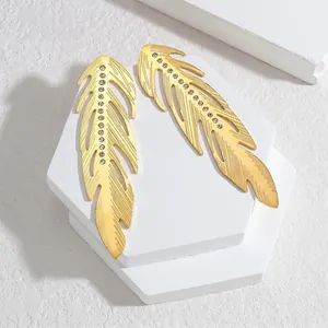Élégantes boucles d'oreilles plume dorées avec strass blancs sur support épuré