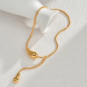 Minimalist titanium steel snake chain necklace with gold teardrop tassels on white surface