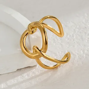 Vue macro d'une bague géométrique dorée ajourée sur fond de pierre blanche