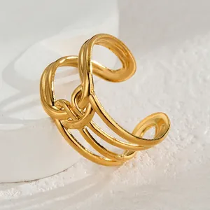 Détail d'une bague ouverte en acier inoxydable doré avec un nœud géométrique