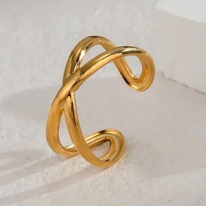 Dettaglio ravvicinato dell'anello aperto in acciaio inossidabile dorato a linee incrociate