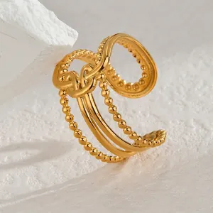 Vue détaillée d'une bague dorée multicouche avec nœuds torsadés et bords perlés
