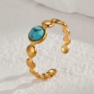 Macro detail of vintage gold-plated open ring with turquoise inlay on stone surface