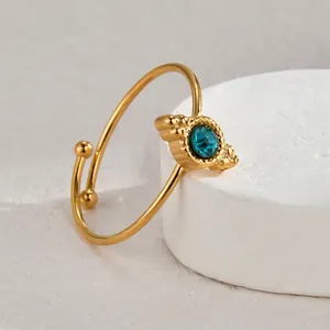 Elegant gold-plated open bangle featuring a round light blue gemstone in retro beaded setting