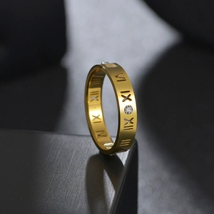 Vista macro de anillo de titanio dorado con números romanos calados y circonitas incrustadas