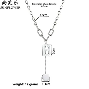 Détail du pendentif lettre B argentée avec chaîne à pampille et disque métallique poli