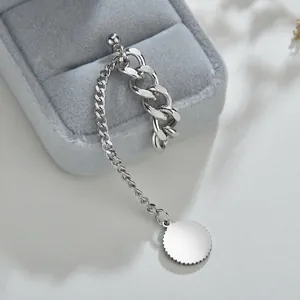 Silver stainless steel chain earrings with circular pendant and tassel design on velvet box