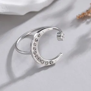 Bague ouverte lune en argent avec zircons étincelants sur une surface grise