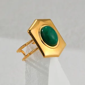 Detail of 18k gold vintage ring with oval green stone and hollow double-layer band
