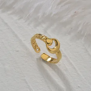 Adjustable golden ring with crescent moon and chain texture on a white stone background