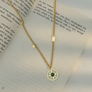 Collier soleil vintage plaqué or 14K avec pendentif malachite verte sur un livre