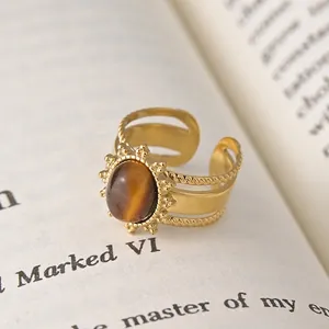 French vintage style 14K gold plated open ring with oval tiger eye stone on a book