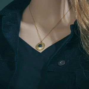 Vintage gold turquoise disc pendant necklace with retro patterns on a female model