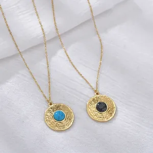 Bohemian gold chain necklaces with turquoise and black marble pendants on white linen