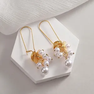 Vintage style gold hook earrings with white pearl clusters and matte gold disc charms
