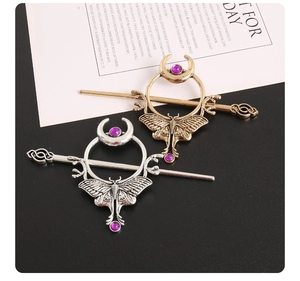 Detail von Vintage Haarnadeln mit Mond, Motte, lila Edelsteinen und Metalltexturen