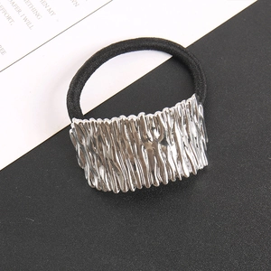 Detail of minimalist hair tie featuring a silver metal plate with irregular vertical textures