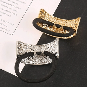 Dettaglio di elastici per capelli metallici con motivi floreali a sbalzo in oro e argento
