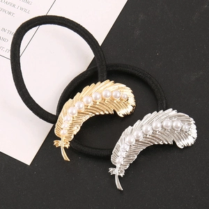 Detail view of vintage alloy feather hair ties with pearls in gold and silver finish