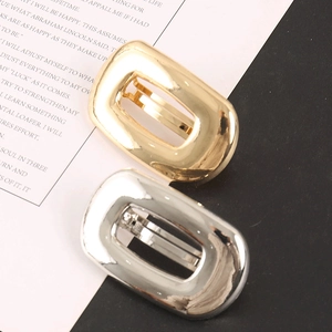 Detail of minimalist rectangular hollow metal hair clips in polished gold and silver finishes