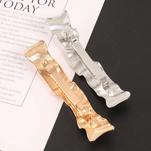 Minimalist wavy metal hair clips in gold and silver finish with anti-slip texture