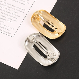 Detail view of gold and silver alloy spring hair clips with textured metallic finish