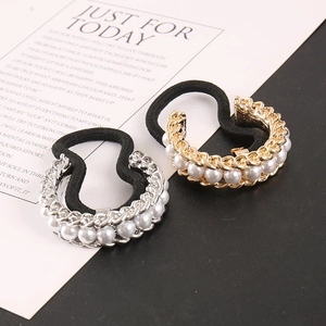 Detail of luxury pearl metal hair ties with gold and silver double-layered chain design