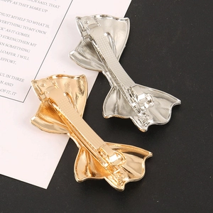 Detailed view of gold and silver butterfly hair clips showing spring clasp mechanism