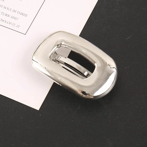 Close-up of a silver rectangular hollow metal hair clip with a polished mirror finish