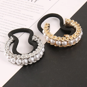 Close-up of metal hair ties with gold and silver finishes and inlaid white pearls