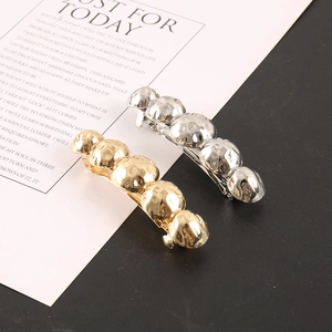 Detailed macro view of gold and silver bubble alloy hair clips with hammered metal texture