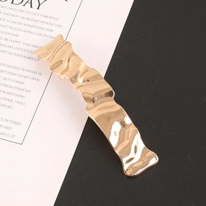 Elegant gold alloy hair clip with irregular ripple texture on minimalist black-white background