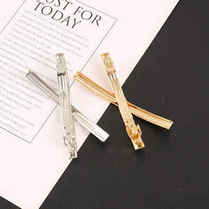 Barrettes à cheveux polies en or et argent sur des supports en papier décoratifs