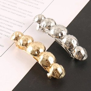 Detailed close-up of beaded alloy hair clips in gold and silver with hammer texture