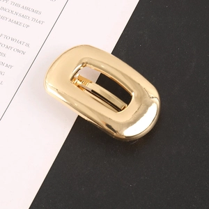 Detailed close-up of golden hollow rectangular alloy hair clip with elegant glossy finish