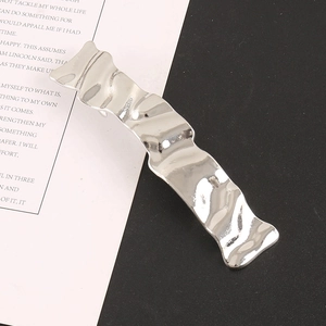 Minimalist silver wavy metal hair clip with a sleek polished finish on a modern backdrop