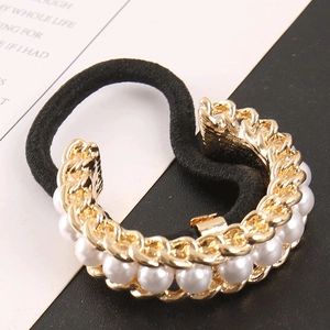 Detailed close-up of pearl chain hair tie with gold links on high-elastic black band