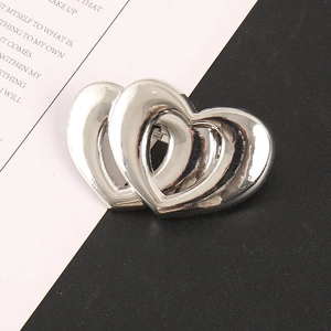 Détail macro d'un accessoire cheveux cœur en argent poli avec design double cœur ajouré